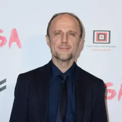 Łukasz Simlat, znany z wielu ról filmowych, na tle napisu "JUGA".