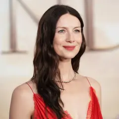 Caitriona Balfe w czerwonej sukni, z delikatnym uśmiechem. Marzy o swoich dzieciach, które pewnie są równie urocze.