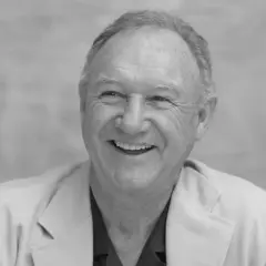 Uśmiechnięty Gene Hackman, którego już nie ma, w jasnej marynarce.