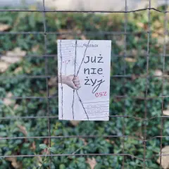 Okładka książki "Już nie żyjesz" Krzysztofa Koziołka, wisząca na płocie. Wstrząsająca historia, która skłania do myślenia, jak zasady przyjemności serial.