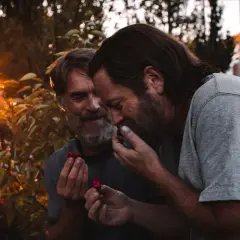Bill z The Last of Us dzieli się malinami z ukochanym, w ciepłym świetle zachodzącego słońca.