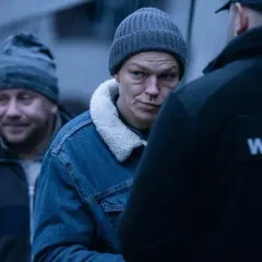 Mężczyzna w czapce i dżinsowej kurtce patrzy na funkcjonariusza Służby Więziennej. Scena z jednego z polskich seriali Canal Plus.