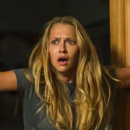 Przerażona blondynka z otwartymi ustami, kiedy gasną światła, obsada filmu "Kiedy gasną światła" w dramatycznej scenie.