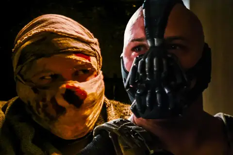 Tom Hardy jako Bane w masce i postać z zabandażowaną twarzą.