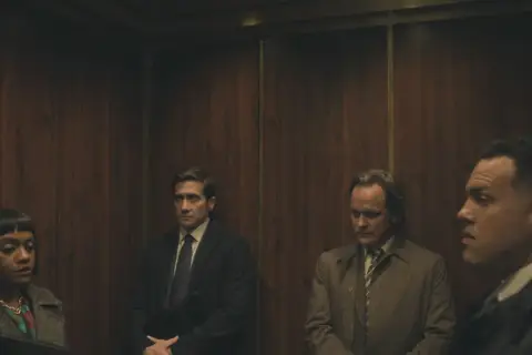 Cztery osoby w windzie, w tym Jake Gyllenhaal, w scenie z serialu "Uznany za niewinnego".