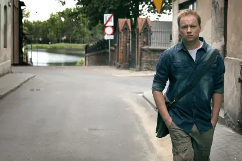 Mężczyzna w dżinsowej koszuli idzie ulicą. Czy zastanawia się, ile odcinków ma "Belfer 1"?
