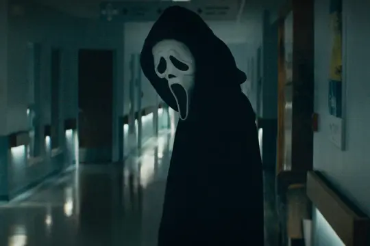 Ghostface w czarnej szacie stoi na szpitalnym korytarzu. Ile jest części krzyku? To pytanie zadaje sobie każdy fan horroru.