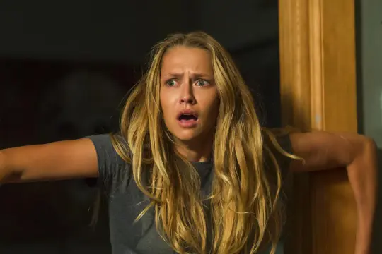 Przerażona blondynka z otwartymi ustami, kiedy gasną światła, obsada filmu "Kiedy gasną światła" w dramatycznej scenie.