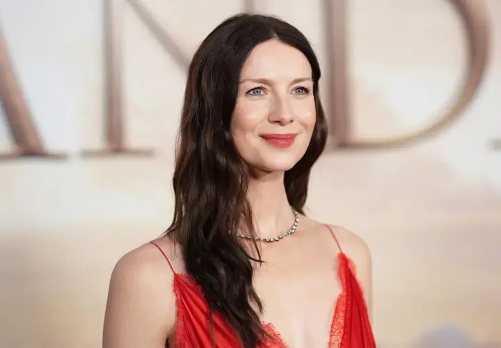 Caitriona Balfe w czerwonej sukni, z delikatnym uśmiechem. Marzy o swoich dzieciach, które pewnie są równie urocze.