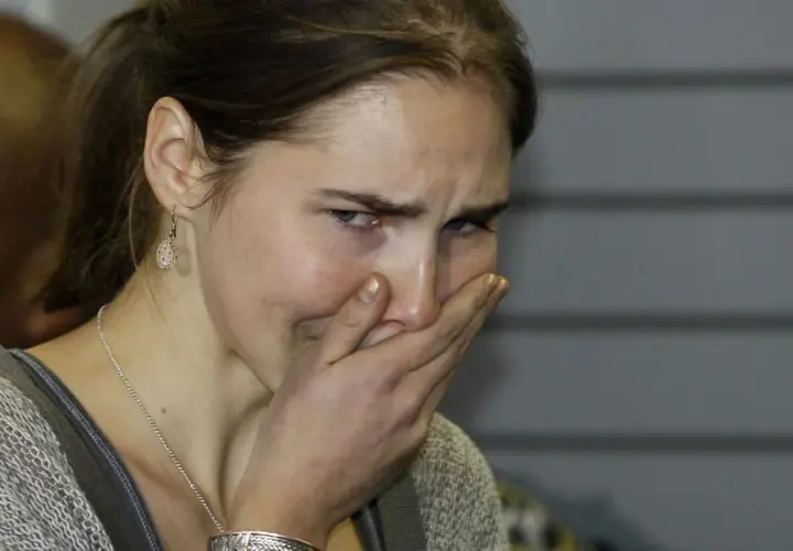 Amanda Knox, z ręką na ustach, wyraża emocje związane ze sprawą.