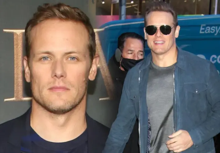 Sam Heughan, znany z roli w Outlander, w okularach przeciwsłonecznych i niebieskiej kurtce. W tle widać fragment logo i napis "covid testing".