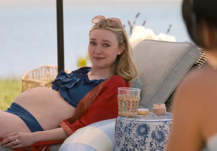 Dakota Fanning, w ciąży, odpoczywa na leżaku przy wodzie. Wygląda na szczęśliwą, jakby czekała na swoje dziecko.
