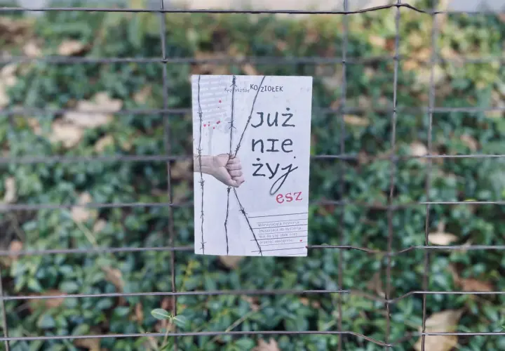 Okładka książki "Już nie żyjesz" Krzysztofa Koziołka, wisząca na płocie. Wstrząsająca historia, która skłania do myślenia, jak zasady przyjemności serial.