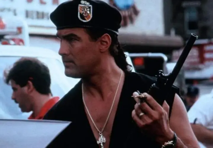 Steven Seagal w beretce i z naszyjnikiem, trzymający krótkofalówkę. W jakich filmach grał Steven Seagal?