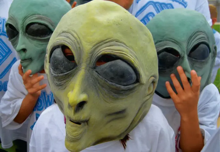 Dzieci w maskach obcych, jak z Roswell w Nowym Meksyku, pozują do zdjęcia.