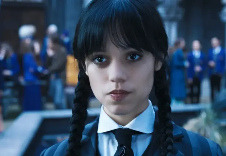 Wednesday Addams w okularach i krawacie, z niecierpliwością czekająca na drugi sezon.