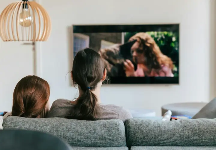 Dwie osoby oglądają film na telewizorze. Szukają sposobu, jak znaleźć film, którego tytułu nie pamiętam, opisując scenę z ekranu.