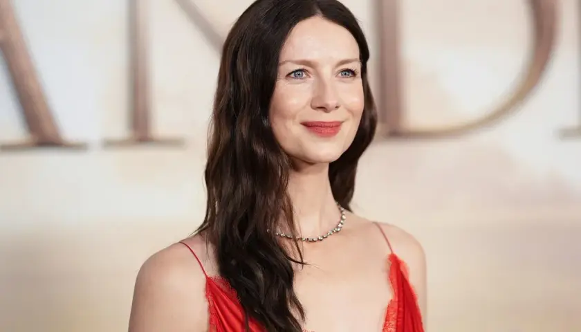 Caitriona Balfe w czerwonej sukni, z delikatnym uśmiechem. Marzy o swoich dzieciach, które pewnie są równie urocze.