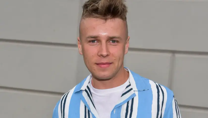 Młody mężczyzna z fryzurą na jeża, w koszuli w paski, wygląda jakby miał zagrać rolę w filmie. Czy Skolim jest aktorem?