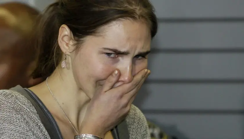 Amanda Knox, z ręką na ustach, wyraża emocje związane ze sprawą.