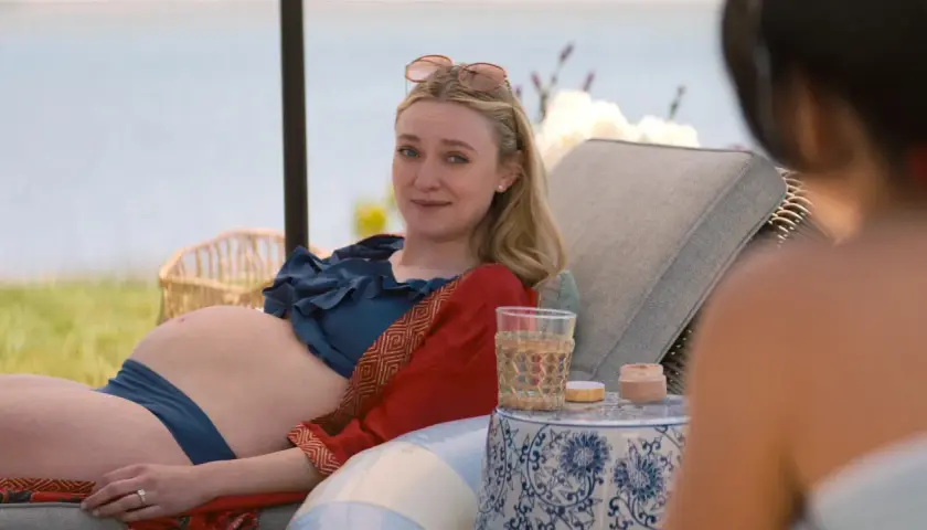 Dakota Fanning, w ciąży, odpoczywa na leżaku przy wodzie. Wygląda na szczęśliwą, jakby czekała na swoje dziecko.