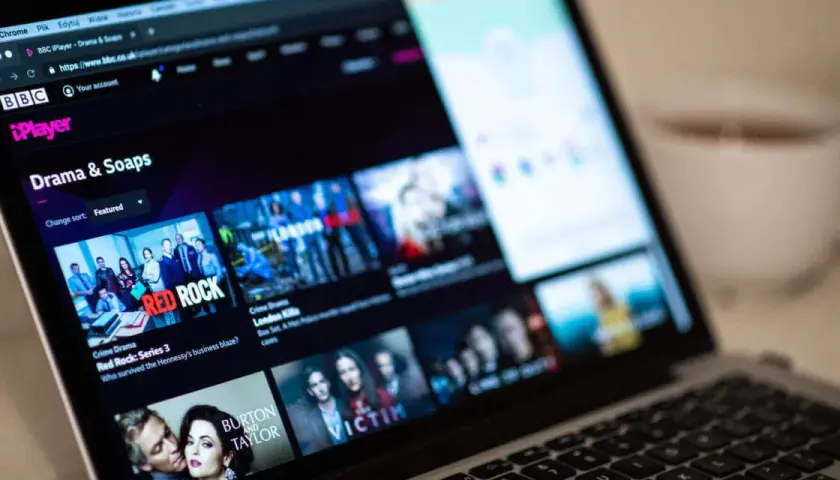Ekran laptopa z interfejsem BBC iPlayer Polska, wyświetlający kategorie "Drama & Soaps" i okładki seriali takich jak "Red Rock".