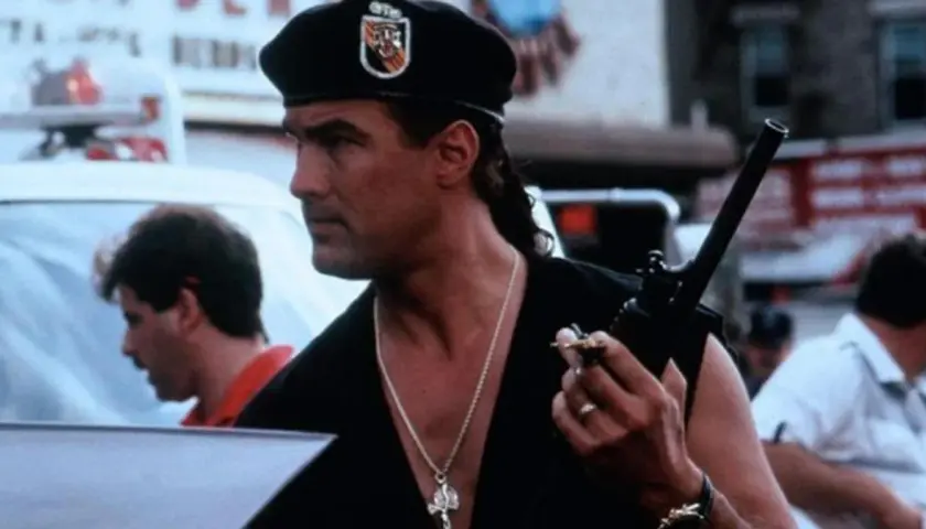 Steven Seagal w beretce i z naszyjnikiem, trzymający krótkofalówkę. W jakich filmach grał Steven Seagal?
