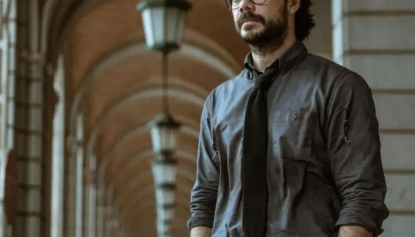 Profesor z Domu z Papieru w okularach i rozpiętej koszuli, planujący kolejny skok.