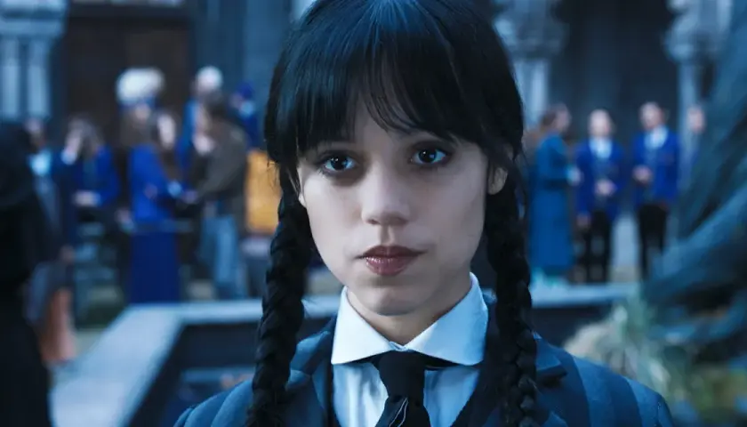 Wednesday Addams w okularach i krawacie, z niecierpliwością czekająca na drugi sezon.