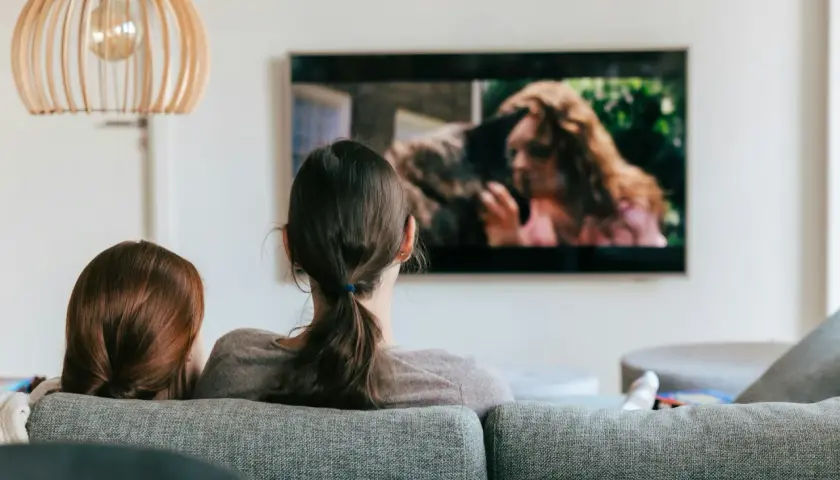 Dwie osoby oglądają film na telewizorze. Szukają sposobu, jak znaleźć film, którego tytułu nie pamiętam, opisując scenę z ekranu.