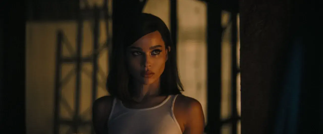 Zoë Kravitz jako Kobieta-Kot w białej podkoszulce, z mocnym makijażem oczu.
