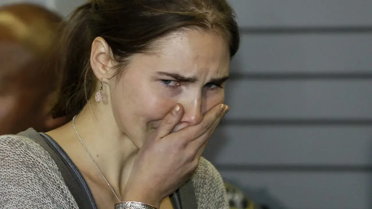 Amanda Knox, z ręką na ustach, wyraża emocje związane ze sprawą.