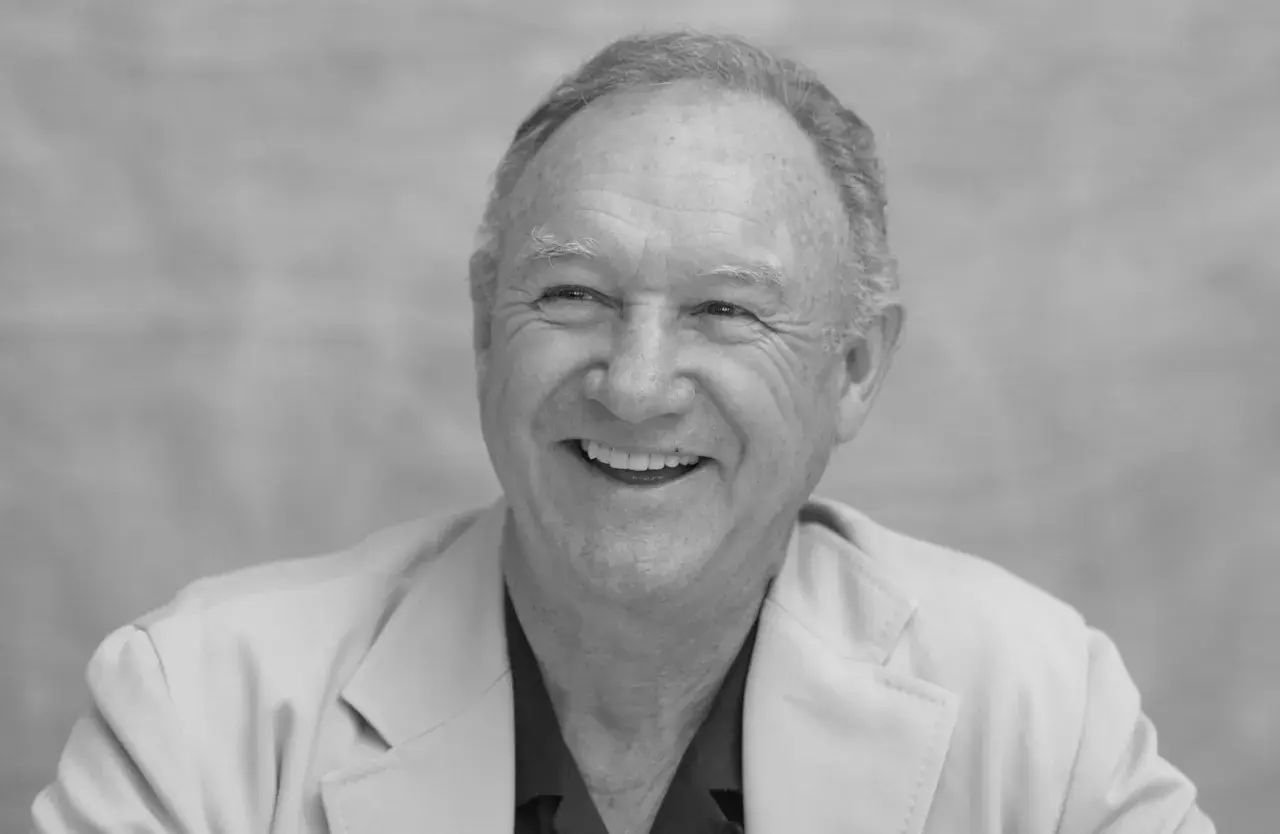 Uśmiechnięty Gene Hackman, którego już nie ma, w jasnej marynarce.