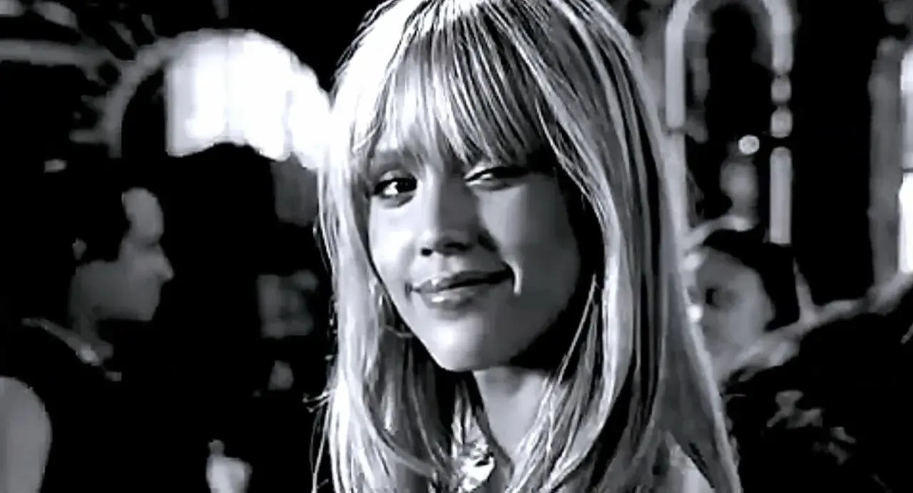 Jessica Alba w roli Nancy Callahan z Sin City, zmysłowo się uśmiecha.