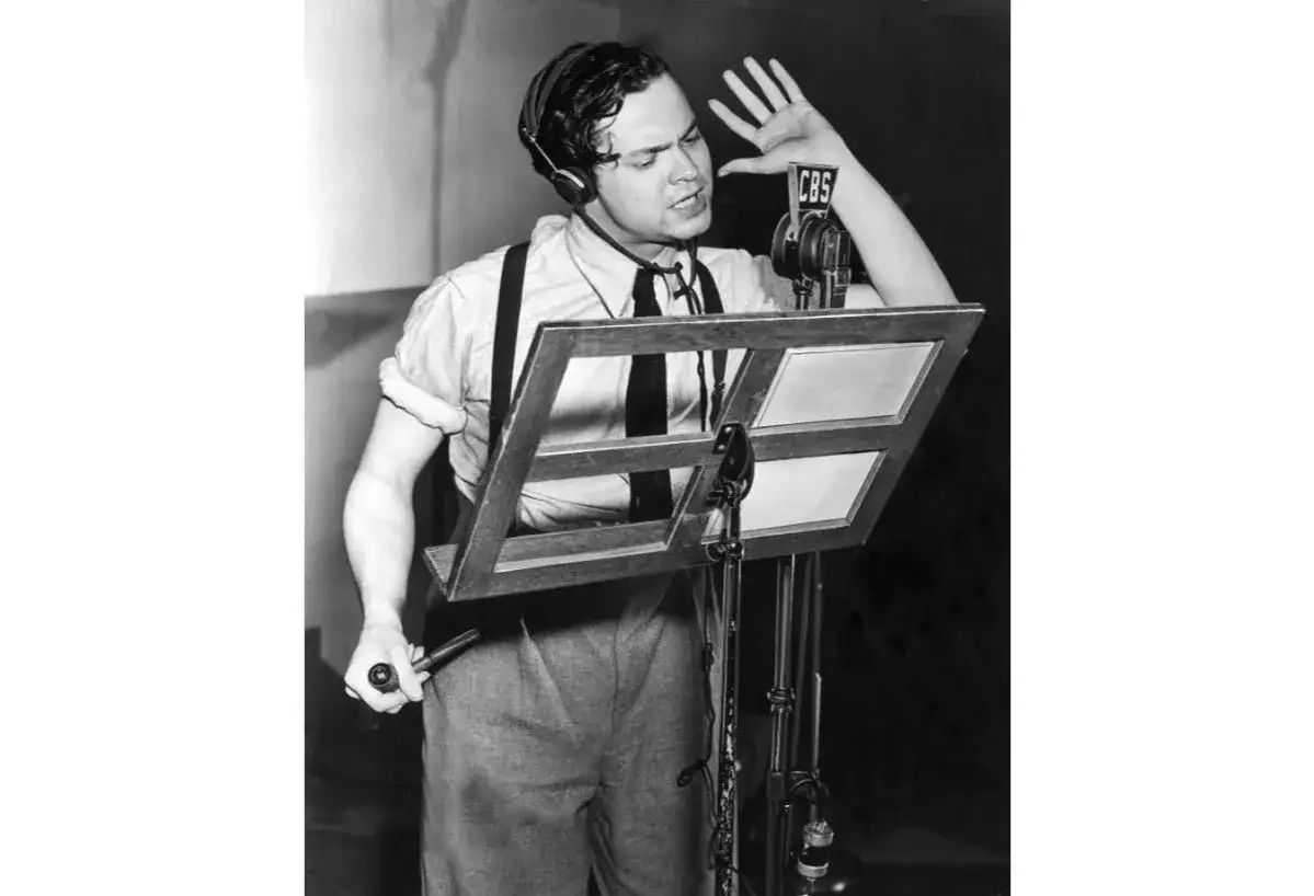 Orson Welles w słuchawkach przy mikrofonie CBS, przygotowuje się do legendarnej audycji 