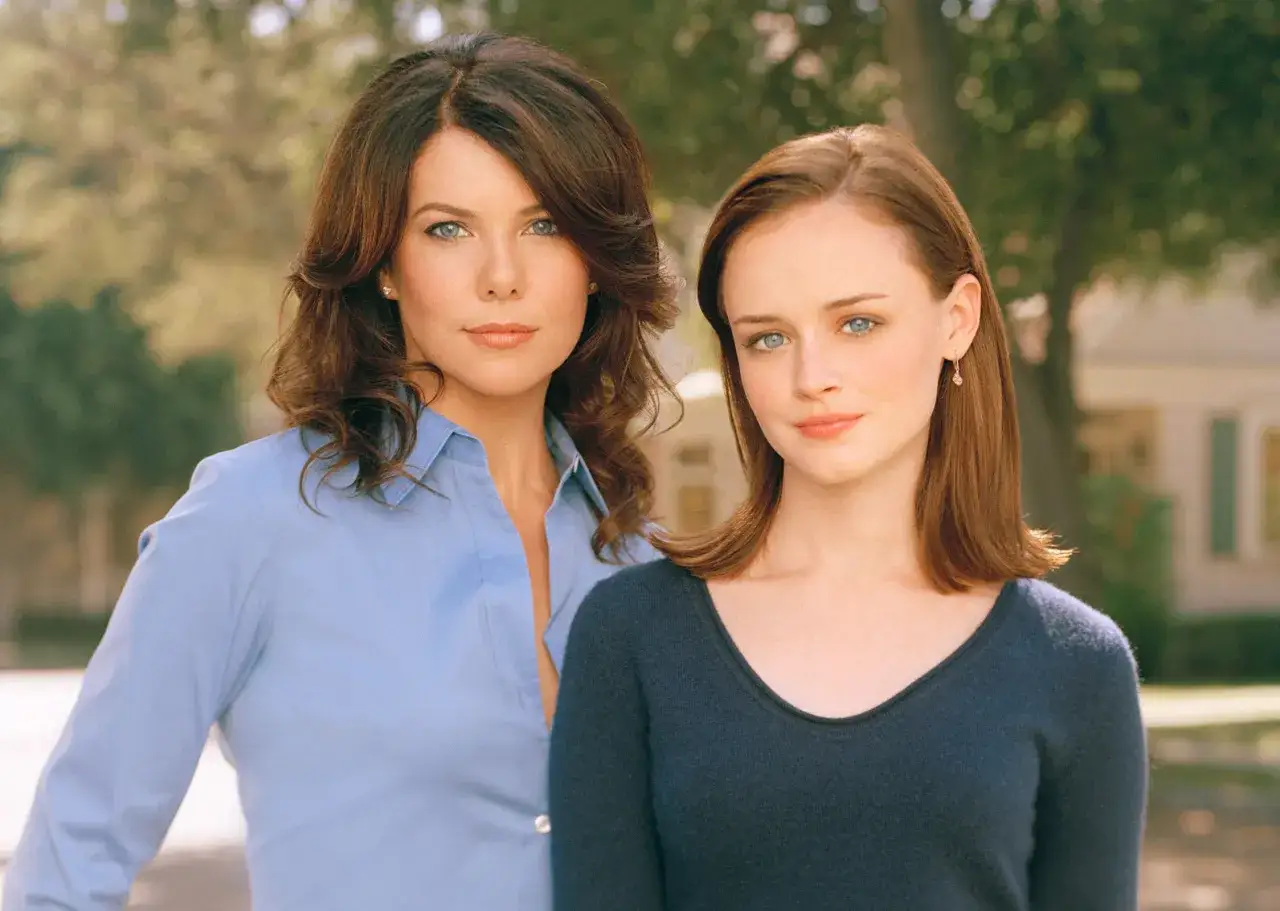 Lorelai i Rory Gilmore, czyli kochane kłopoty rok z życia obsada, pozują do zdjęcia na tle drzew.
