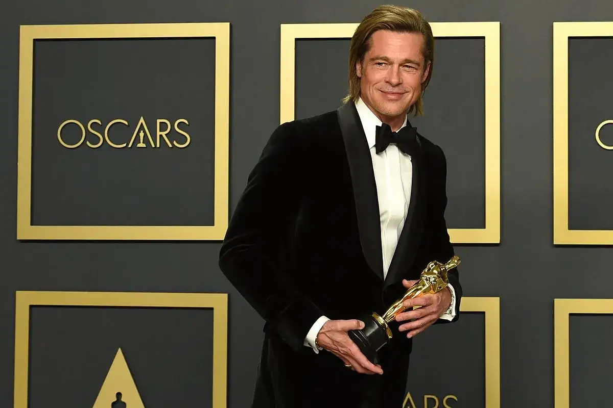 Brad Pitt z Oscarem w ręku, potwierdzając, czy Brad Pitt dostał Oscara.