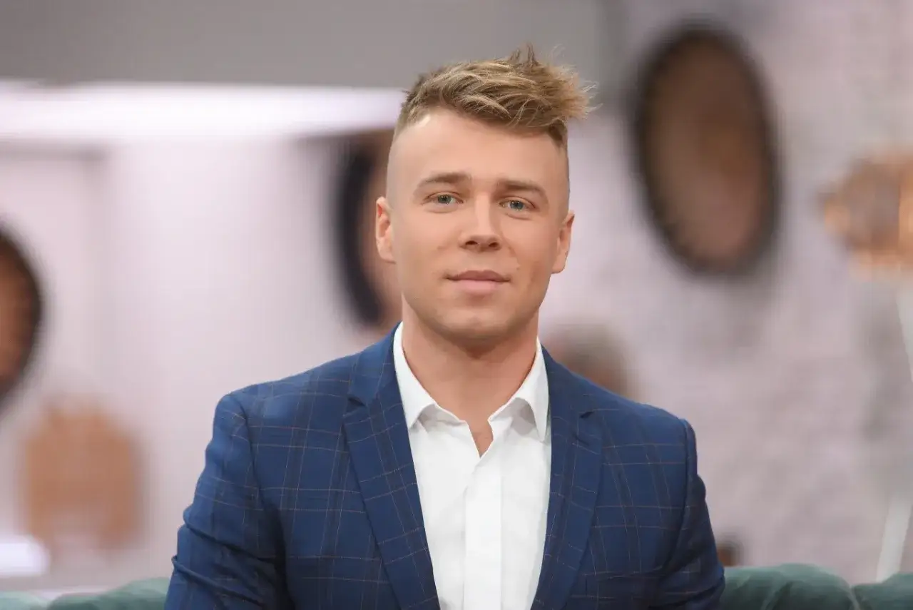 Młody mężczyzna w garniturze, czy Skolim jest aktorem? Jego stylizacja sugeruje, że może grać rolę w filmie lub serialu.