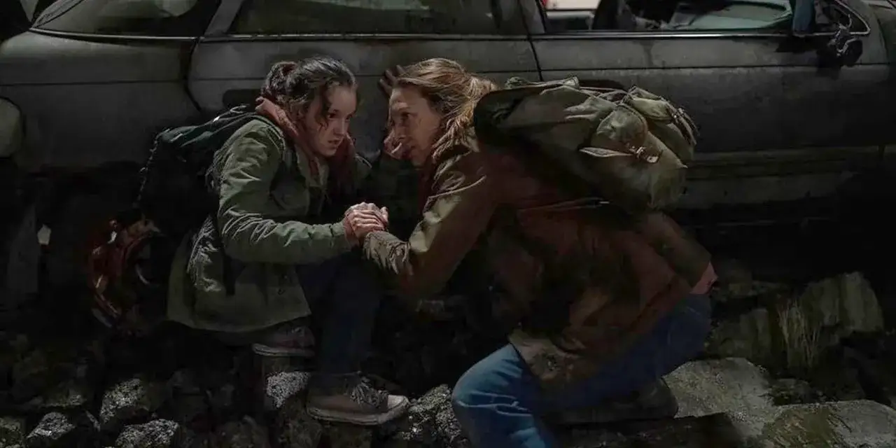 Ellie i Joel, bohaterowie The Last of Us, trzymają się za ręce przy wraku samochodu. Ich spojrzenia pełne są nadziei i determinacji, niczym świetliki w mroku.