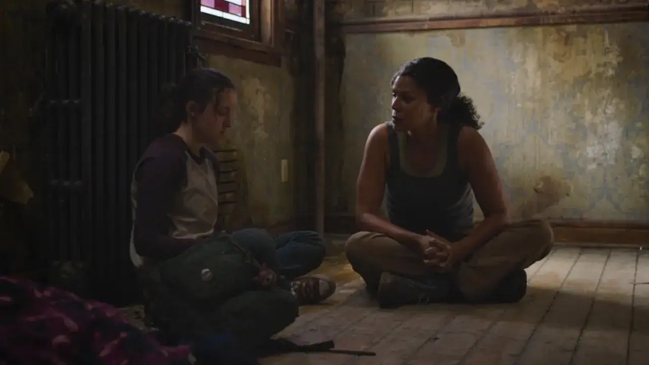 Ellie i Marlene siedzą na podłodze w zniszczonym pokoju, rozmawiając o świetlikach w The Last of Us.