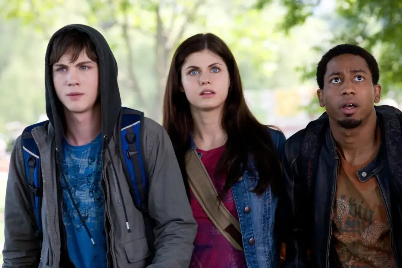 Trójka młodych bohaterów, Percy Jackson serial, wygląda na zaniepokojonych, gdy patrzą w górę.