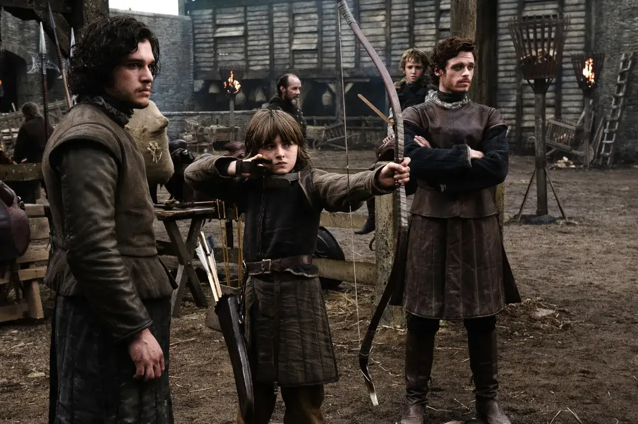 Jon Snow i jego bracia ćwiczą łucznictwo. Młody Bran celuje z łuku, podczas gdy Robb i Jon obserwują.